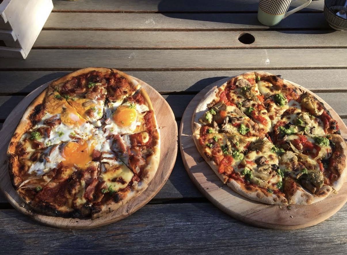 Two wood-fired pizzas served on wooden boards at Mac Butners