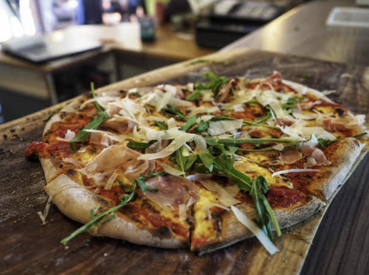 Parma pizza topped with rocket and shaved cheese at Mac Butners